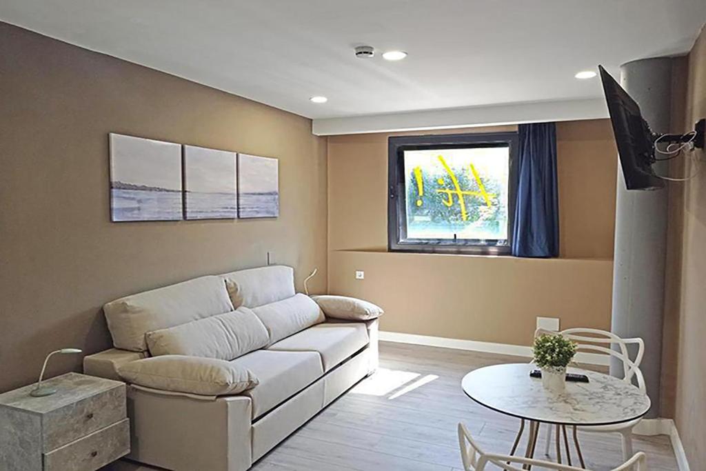 a living room with a couch and a table at Apartamentos Hi Apartaments Santander 3000 in Maliaño