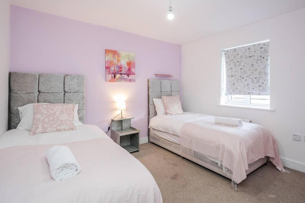 a bedroom with two beds and a window at TMS Cheerful 5BDR house! Thurrock! Free Parking! in Stanford-le-Hope