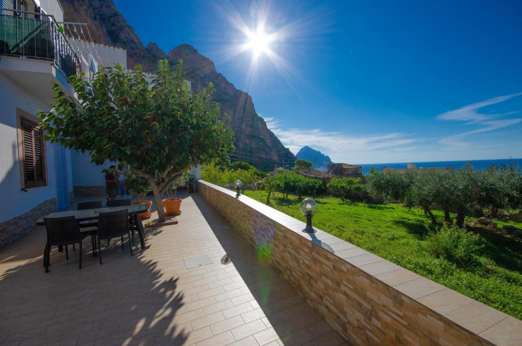 a patio with a table and chairs and a mountain at Appartamenti da Clarissa in Macari