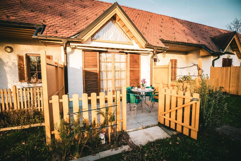 a small house with a wooden fence and a table at POČITNIŠKI APARTMAJI - Trobentica 37 Apartment Golf Moravske Toplice in Moravske Toplice