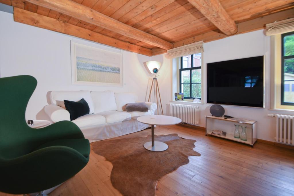 a living room with a white couch and a tv at Kate 60 - Suite Twee in Borkum