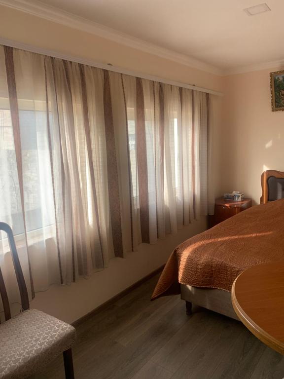 a bedroom with a bed and a table and a window at Ani Hotel in Sisian