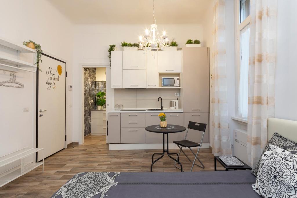 uma cozinha com armários brancos e uma mesa num quarto em Lovely flat - Orti 16 em Milão