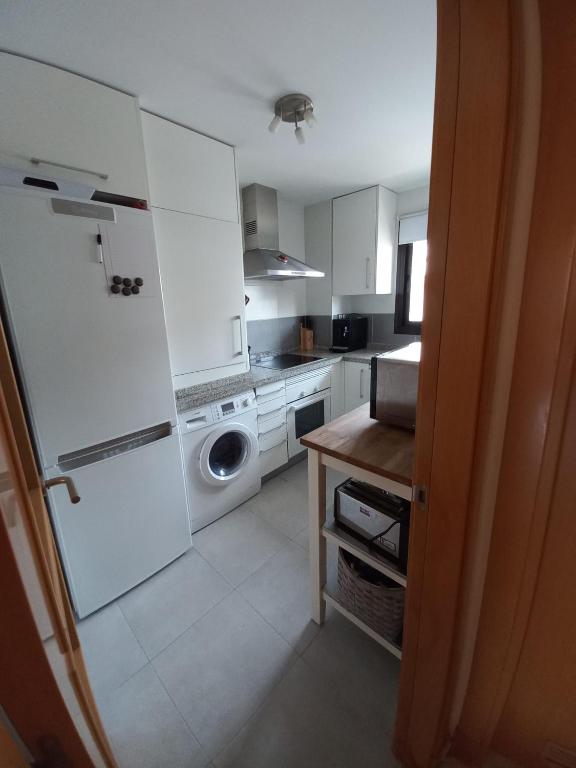 een keuken met witte kasten en een wasmachine en droger bij Nice apartment within walking distance to the center in La Cala de Mijas