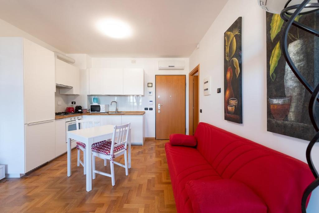 Casa Titty في روما: غرفة معيشة مع أريكة حمراء وطاولة