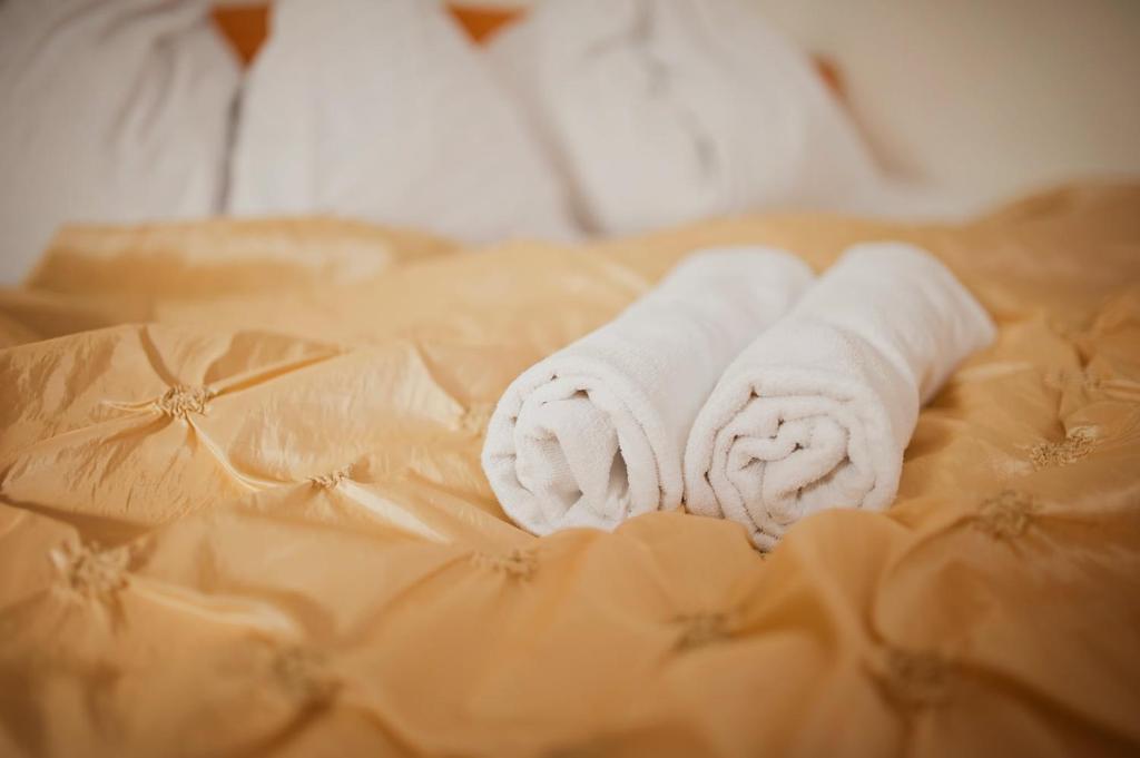 een stapel handdoeken bovenop een bed bij villa Pšenek benessere in Piešťany