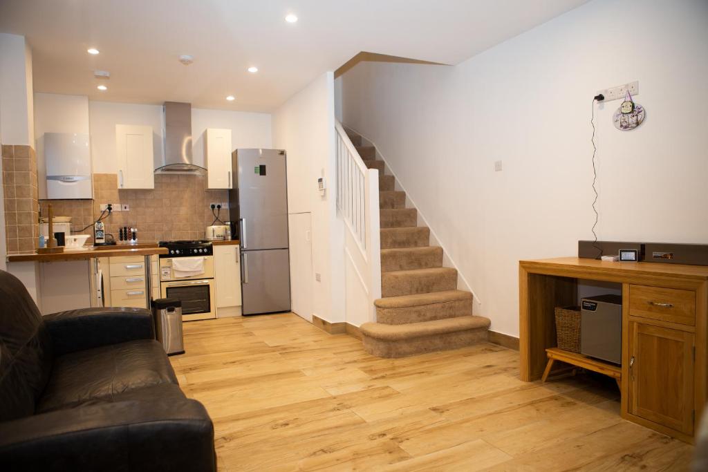 a living room with a staircase and a kitchen at 2 Double bedroom House in Harrow