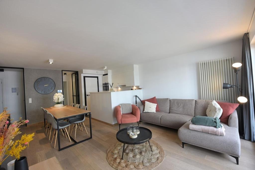 een woonkamer met een bank en een tafel bij Appartement spacieux à Knokke in Knokke-Heist