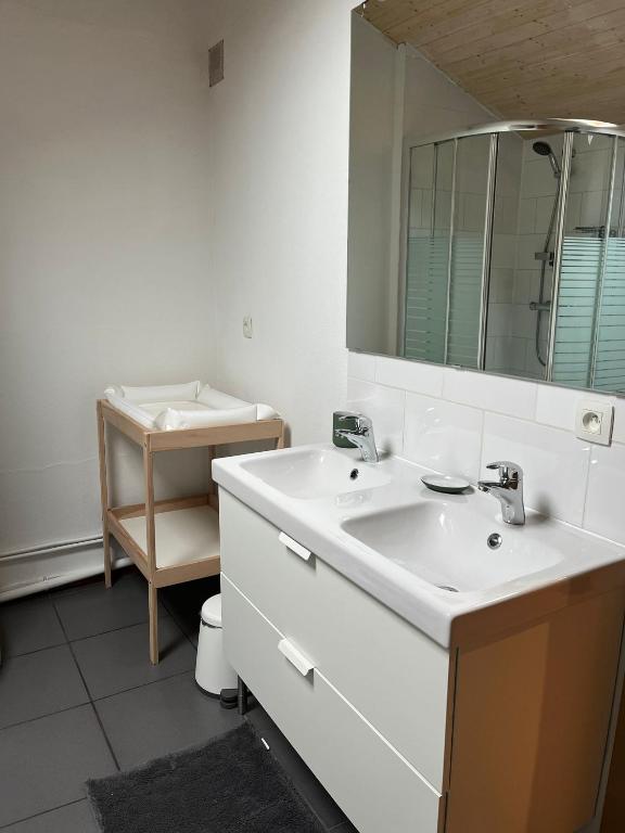 a white bathroom with a sink and a mirror at Gîte Les trois charmes in Gouvy