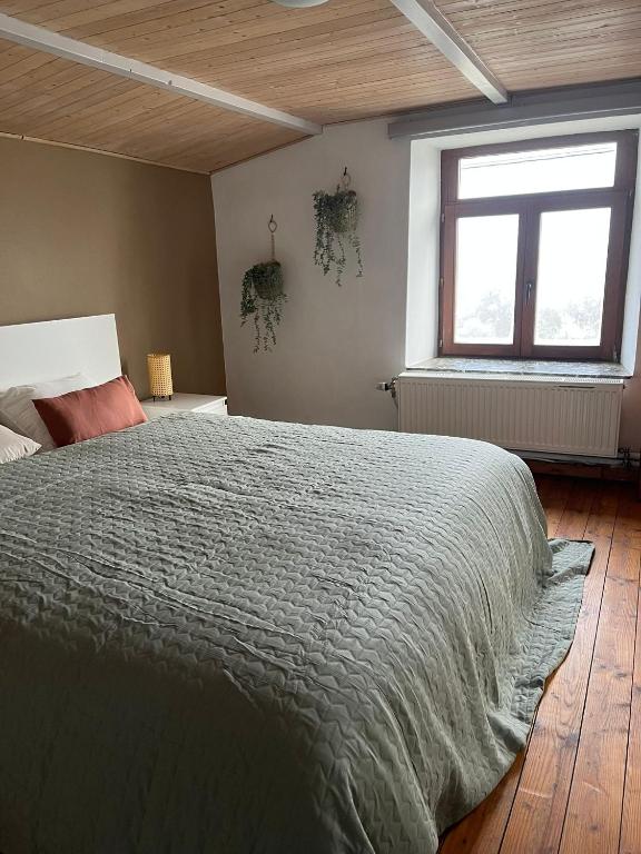 a bedroom with a large bed and a window at Gîte Les trois charmes in Gouvy