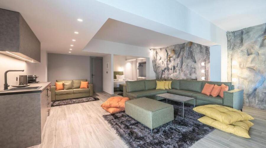 uma sala de estar com um sofá verde e uma cozinha em Snowglory Boutique Hotel em Arachova