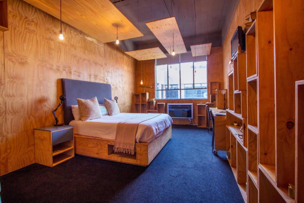 um quarto com uma cama e uma televisão em 12 Decades Art Hotel em Joanesburgo