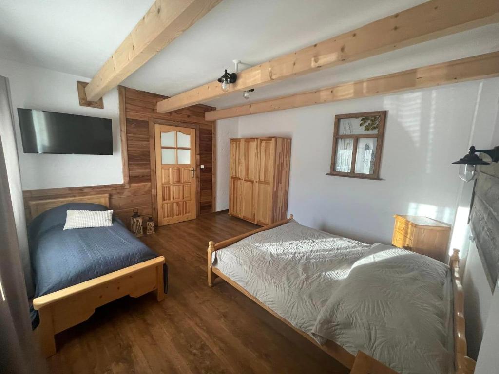a bedroom with a bed and a tv on the wall at Apartament Naglaka in Ząb
