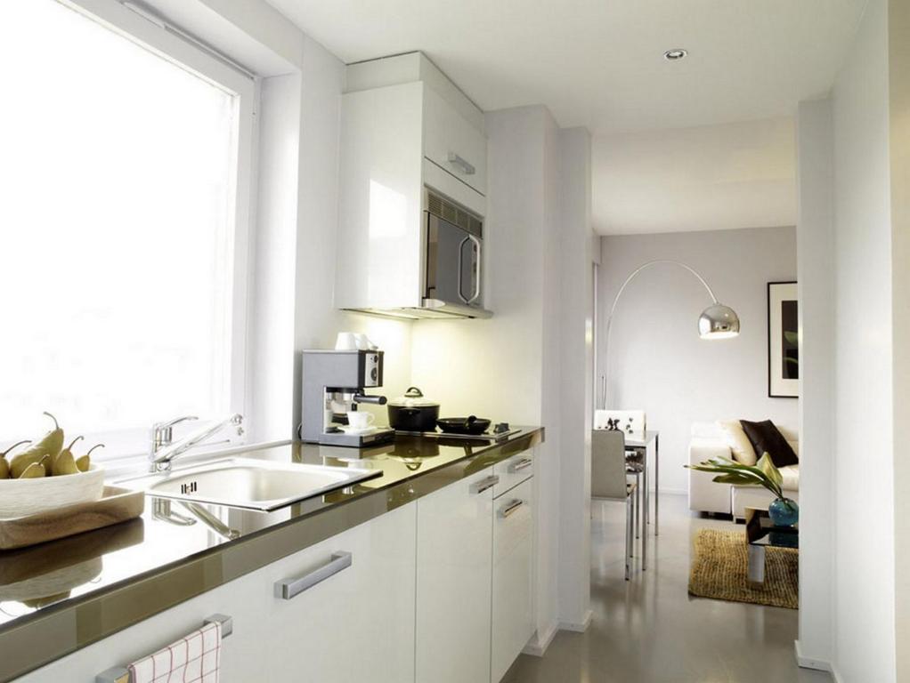 a white kitchen with a sink and a counter at VISIONAPARTMENTS Binzmühlestrasse 48 - contactless check-in in Zürich