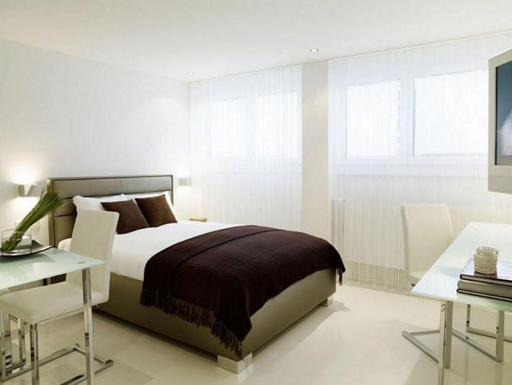 a bedroom with a bed and a table and a desk at VISIONAPARTMENTS Binzmühlestrasse 48 - contactless check-in in Zürich
