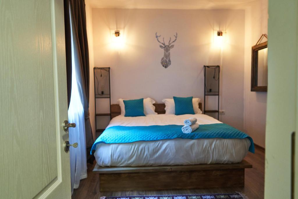 um quarto com uma cama grande e almofadas azuis em Cabana Rose House em Borşa