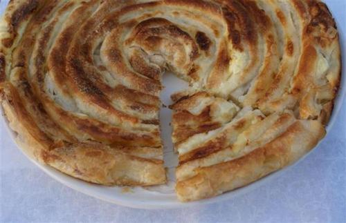 a close up of a pie on a white plate at Dedushi Guesthouse &Wood cabins-Camping place in Gusinje