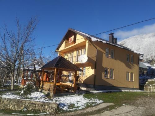 a large house with a gazebo in front of it at Dedushi Guesthouse &Wood cabins-Camping place in Gusinje