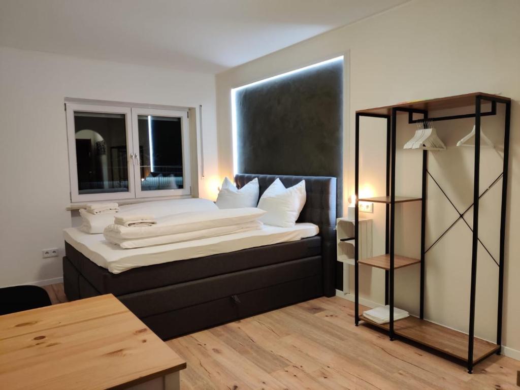 um quarto com uma cama com almofadas brancas e uma janela em Schicke Wohnung in Stadtnähe em Wurtzburgo