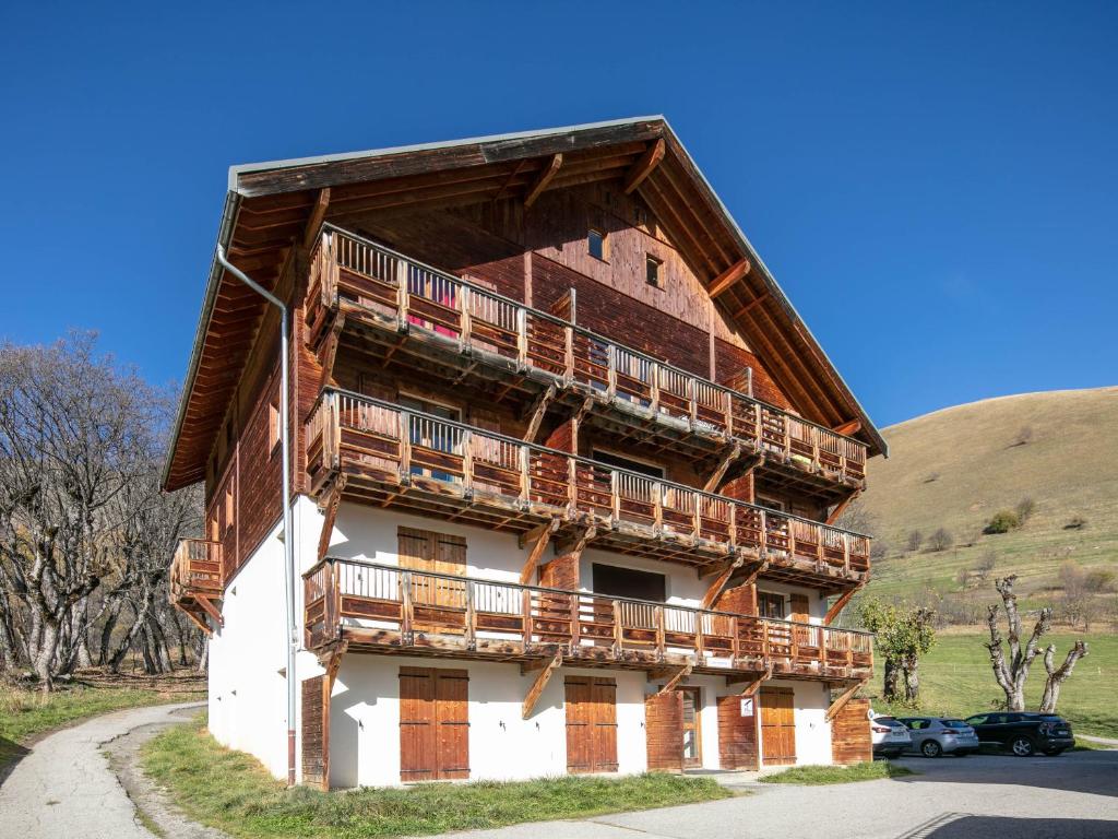 - un bâtiment avec des balcons en bois sur le côté dans l'établissement Vacancéole - Le Hameau de l'Alpage, à Saint-Sorlin-dʼArves