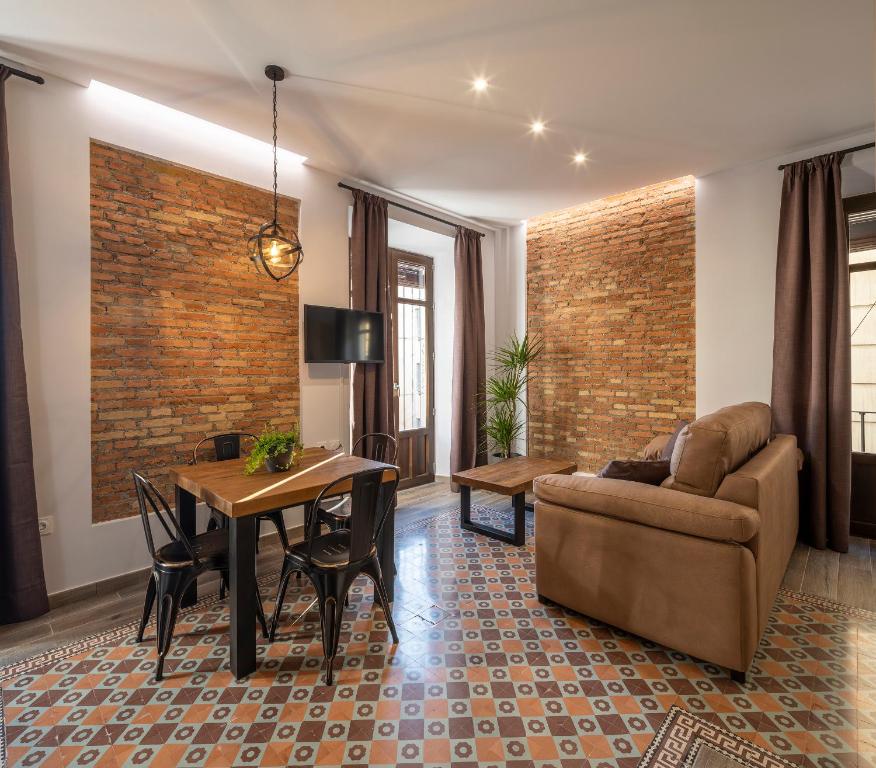 sala de estar con sofá y mesa en Santa Escolástica en pleno centro de Granada en Granada