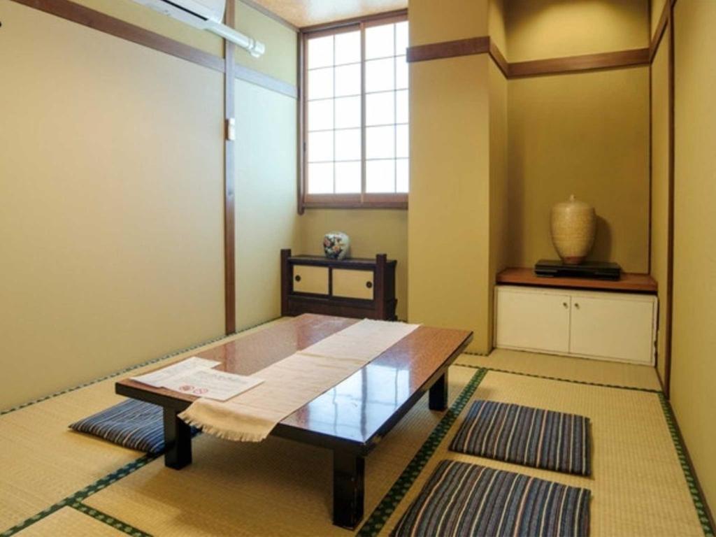 Habitación con mesa de madera y ventana. en Guest houseTakagi - Vacation STAY 60566v, en Matsumoto