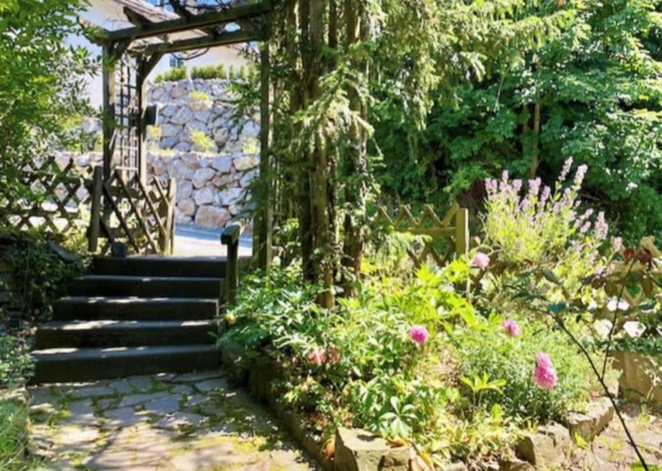 einen Garten mit einem Tor, einer Treppe und Blumen in der Unterkunft Wald Panorama Appartement in Battenberg