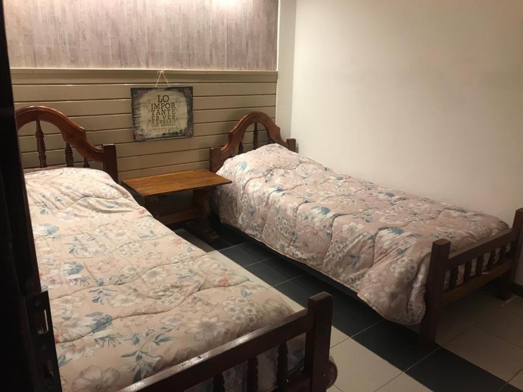 2 camas individuales en una habitación con mesa en yolanda USHUAIA en Ushuaia