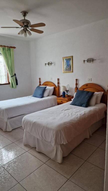 Un dormitorio con dos camas y un ventilador de techo. en Las Brisas 71, en Playa Blanca