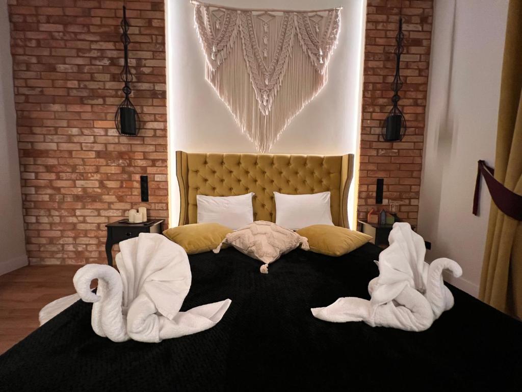 Brick Castle - Apartament Helga في فروتسواف: غرفة نوم عليها سرير وبجعتين