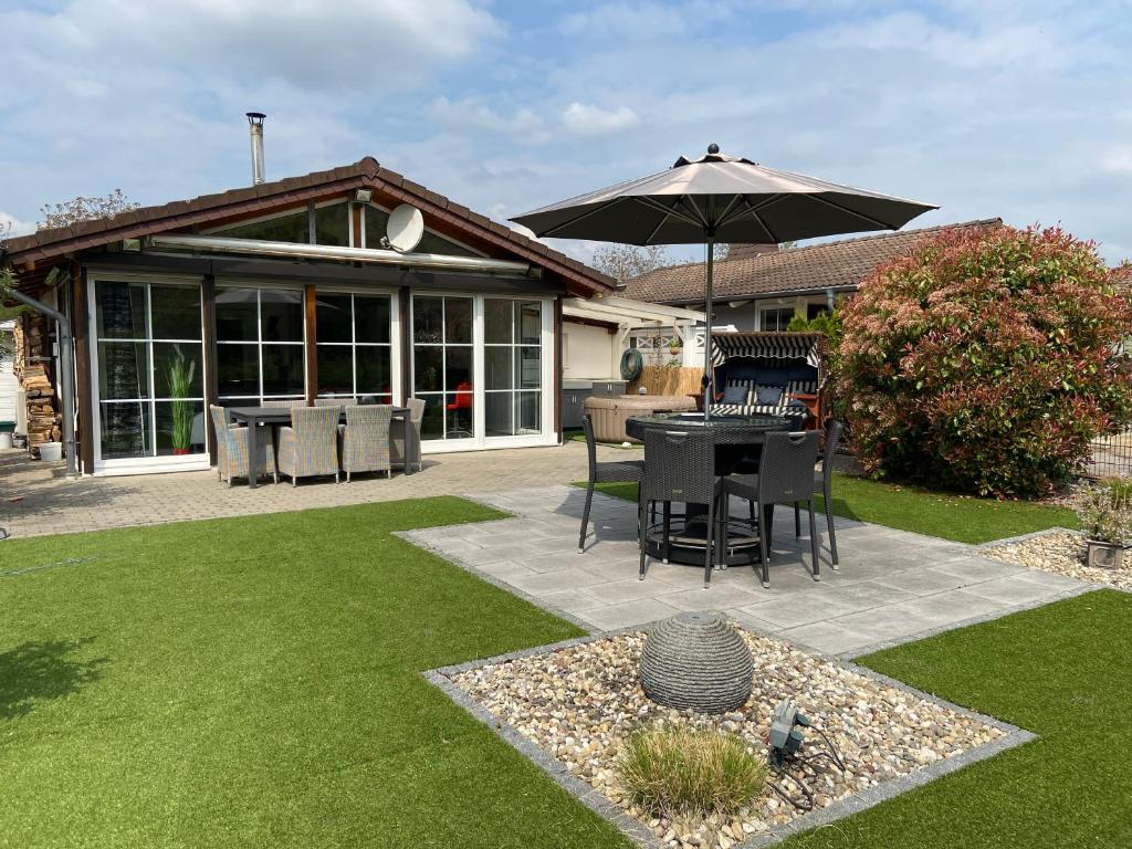 eine Terrasse mit einem Sonnenschirm, einem Tisch und Stühlen in der Unterkunft Moselchalet in Koblenz