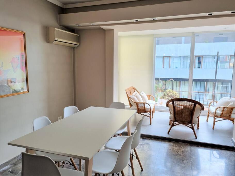 Habitación con mesa, sillas y ventana grande. en Palermo Soho - Luminoso Depto 2 dorms para 4/5 pax en Buenos Aires