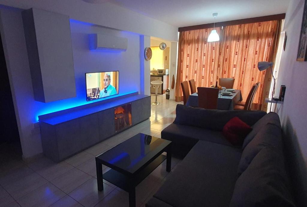 a living room with a couch and a tv at Vasilas Holiday Apartment #2 in Larnaca