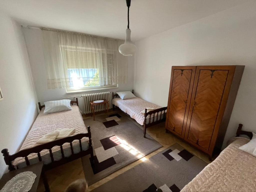 Habitación con 2 camas, vestidor y ventana en Vidikovac Vrnjačka Banja, en Vrnjačka Banja