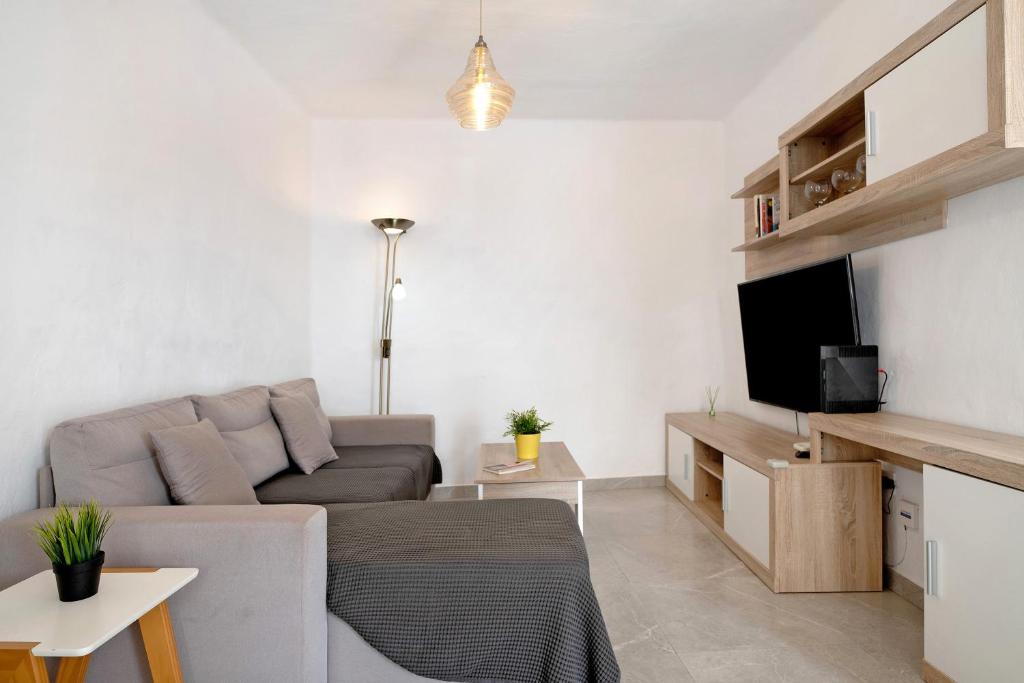 a living room with a couch and a tv at Casa Lía in La Santa