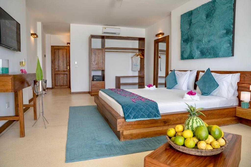 a bedroom with a bed and a bowl of fruit on a table at Imara Beach Resort in Kiwengwa