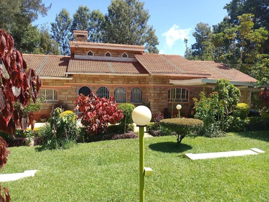 a house in the yard of a garden at Greton Holiday Villa in Meru