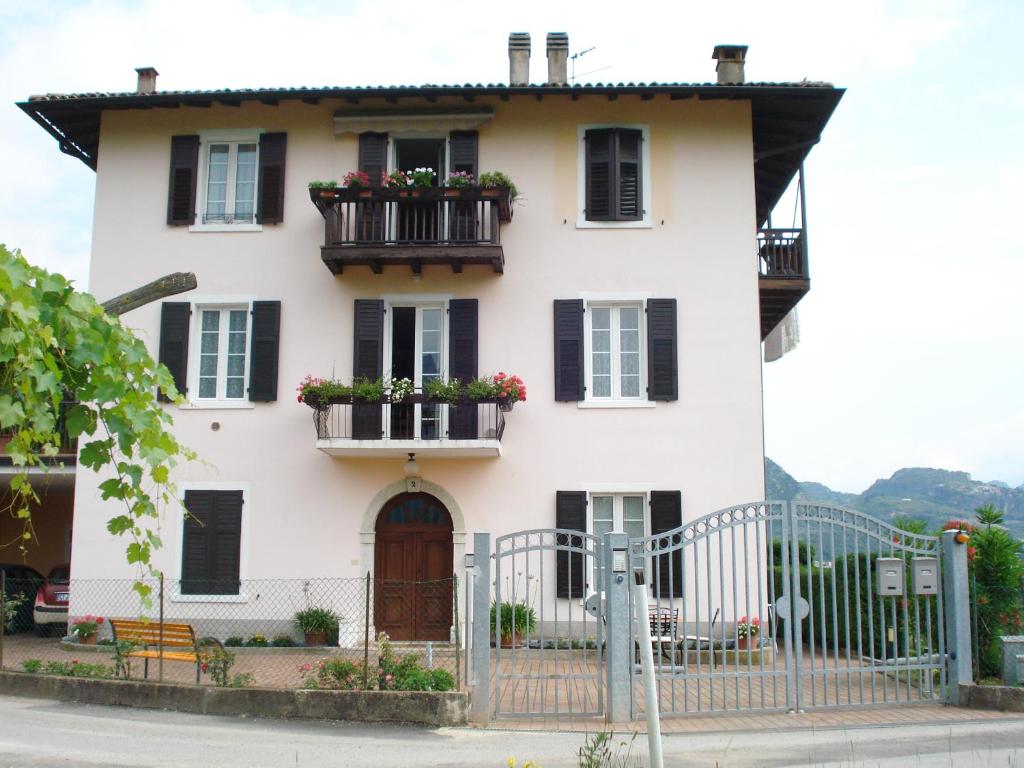 una casa blanca con flores en los balcones en Lidia Apartment, en Riva del Garda