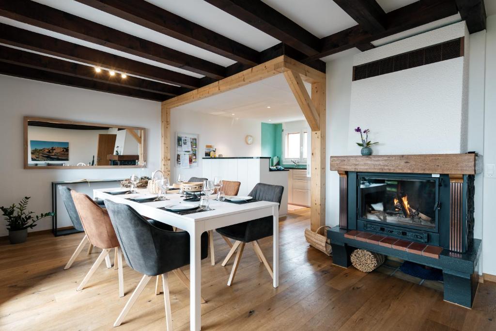 uma sala de jantar com uma mesa e uma lareira em Chalet Ruestel em Amden