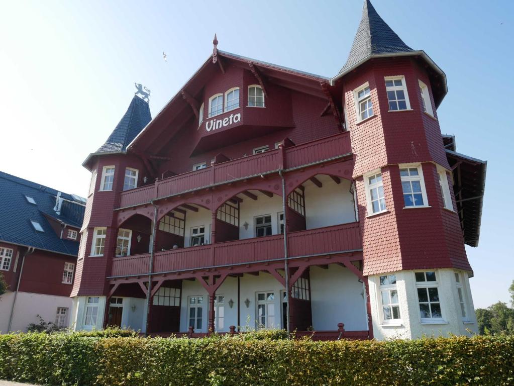 ein großes rotes Gebäude mit einem Turm in der Unterkunft Villa Vineta in Bansin