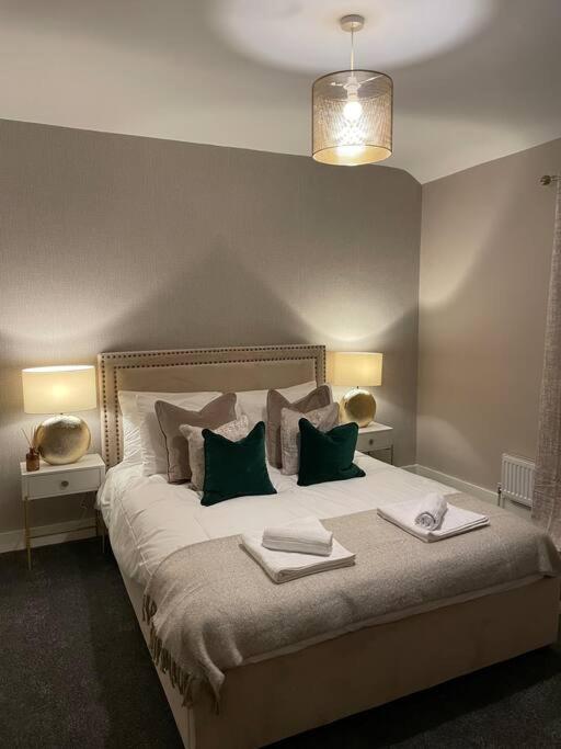 a bedroom with a large bed with green pillows at Stylish 3 Bed Home in Clitheroe in Clitheroe