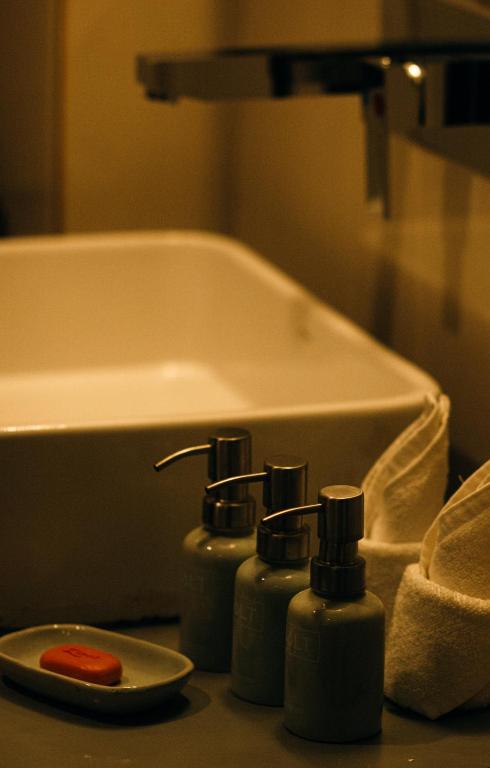 a bathroom with three soap bottles next to a bath tub at Salt Mirissa in Mirissa