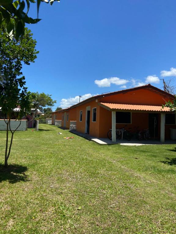 un edificio con un patio de césped delante de él en Pousada da Heloisa, en Imbituba