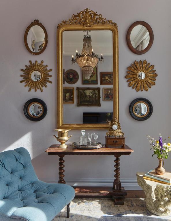 a mirror on a wall with a table and a chair at Pulitzer Amsterdam in Amsterdam