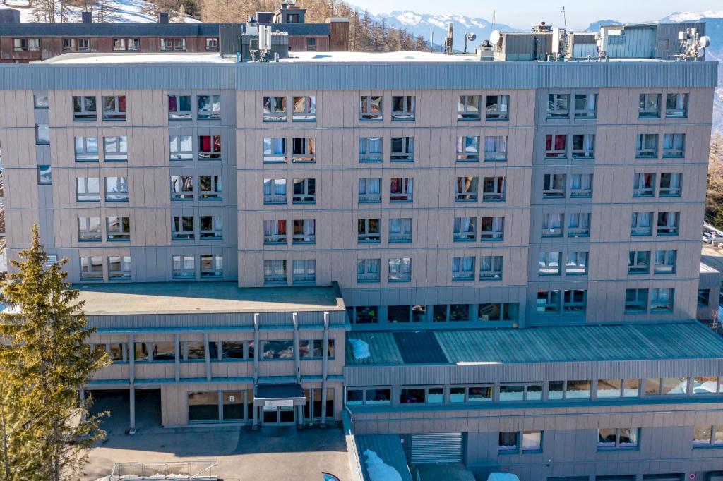 Un gran edificio blanco con muchas ventanas. en Arc en Ciel Les Karellis Vacances Bleues- Ski Pass Inclus, en Montricher-le-Bochet