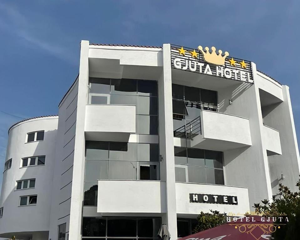 a building with a hotel with a sign on it at HOTEL GJUTA in Tirana