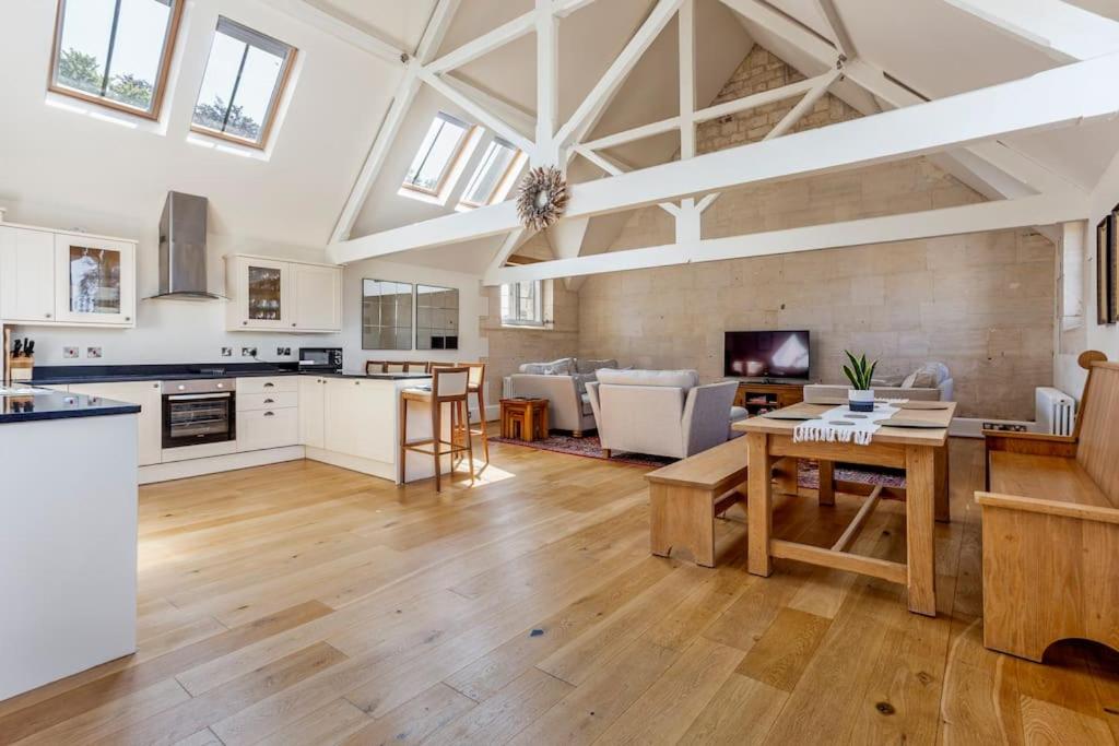 cocina grande y sala de estar con mesa en The Old Library, en Painswick