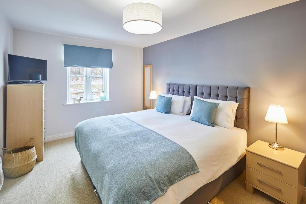 a bedroom with a large bed with blue pillows at Host & Stay - Harbour View in Whitby