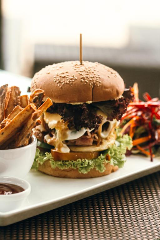 a sandwich on a plate with fries and sauce at Salt Mirissa in Mirissa