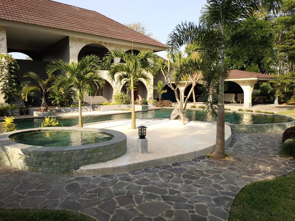 a resort with a swimming pool and palm trees at La Collina Villa in Jepara
